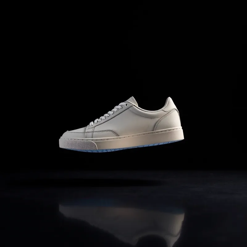Modern sneaker floating above a dark reflective studio surface